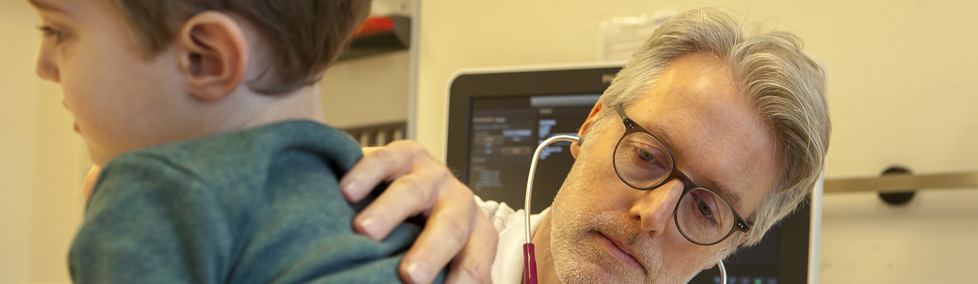 Chefarzt Dr. med. Georg Hillebrand horcht eine Patienten mit dem Stetoskop ab.