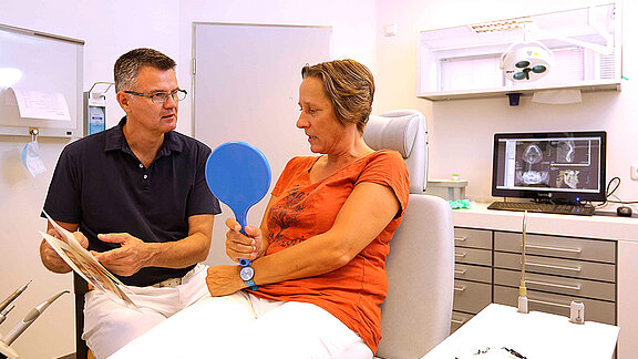 Mund-Kiefer-Gesichtschirurg Dr. Dr. Alexander Tschakaloff im Gespräch mit einer Patientin 