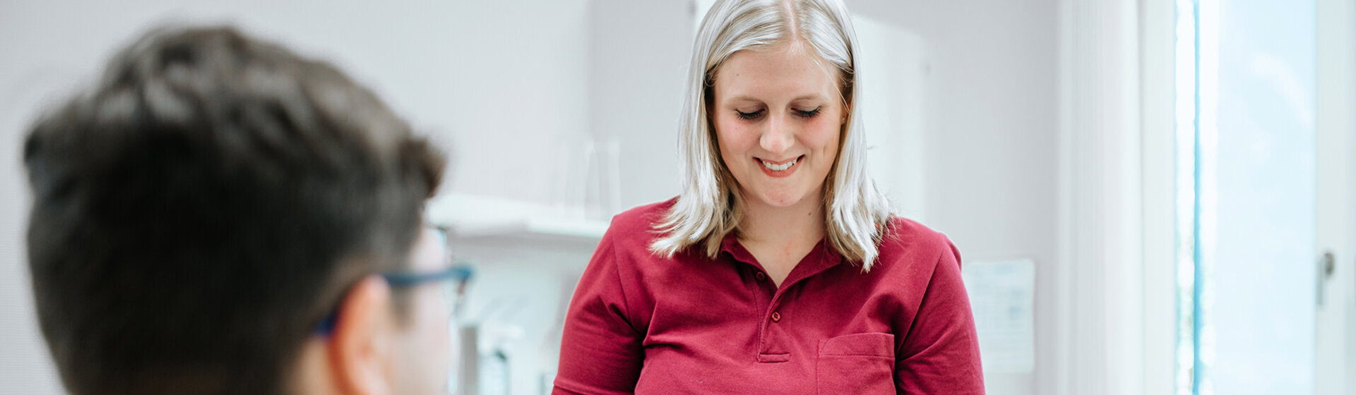 Medizinische Fachangestellte verbindet Hand eines Patienten.