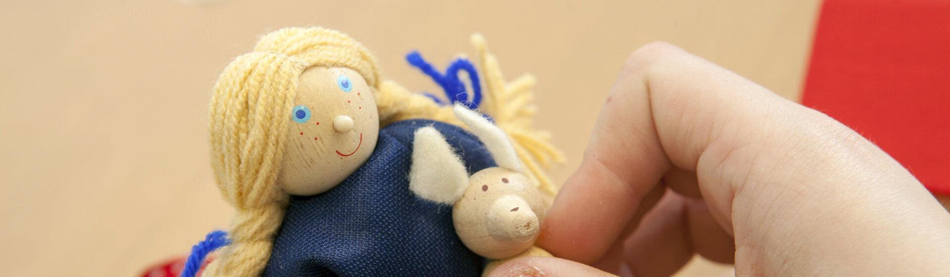 Kinderhände halten eine kleine Puppe.