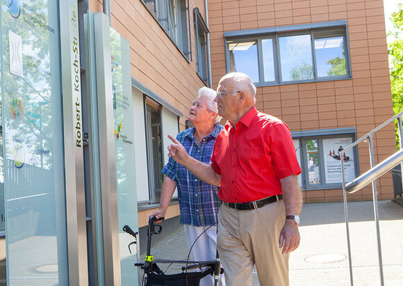 Ärzte- und Dienstleistungszentrum Ein Mann und eine Frau mit Rollator stehen vor dem Ärzte- und Dienstleistungszentrum.