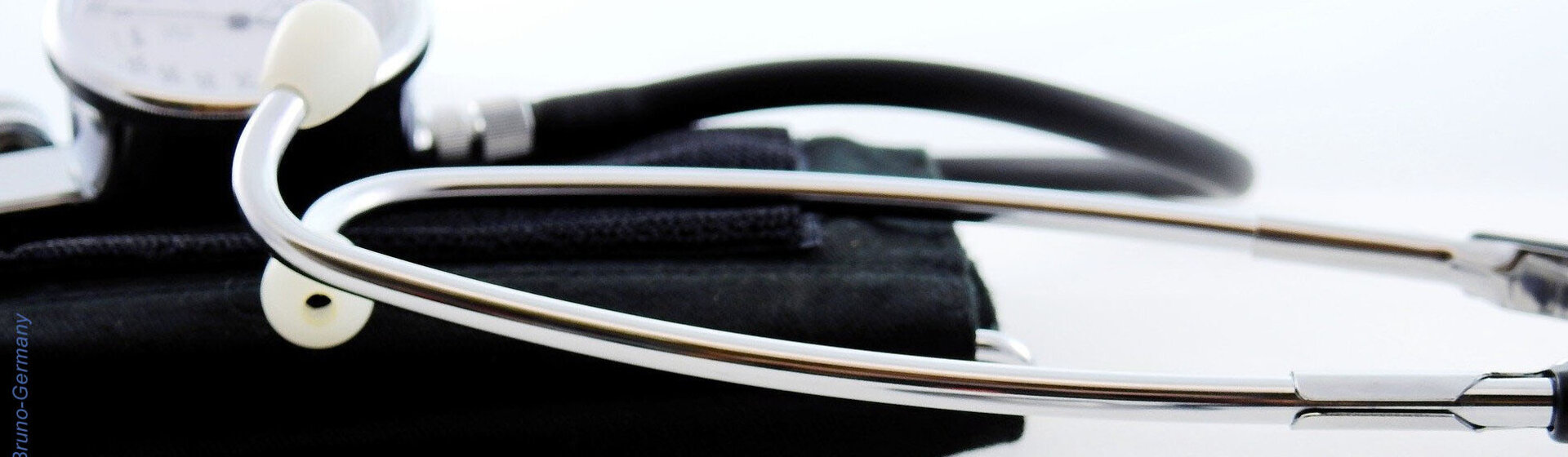 Ein Stetoskop und ein Blutdruckmessgerät liegen auf einem Tisch.