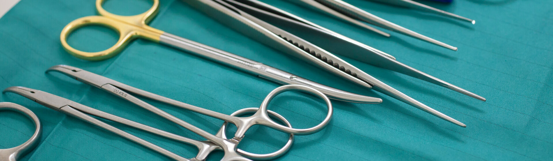 Operationsinstrumente auf einem grünen OP-Tuch