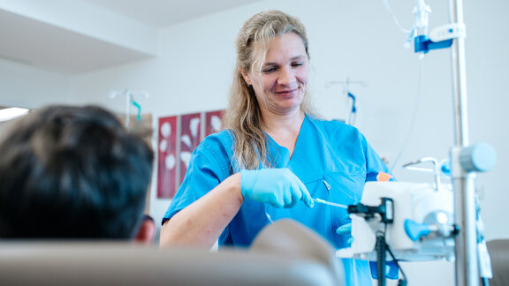 Pflegefachkraft behandelt PatientIn im Onkologisch-therapeutischen Kompetenzzentrum.