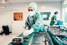 Drei MitarbeiterInnen vom medizinischen Fachpersonal während einer OP. Drei MitarbeiterInnen vom medizinischen Fachpersonal während einer OP.