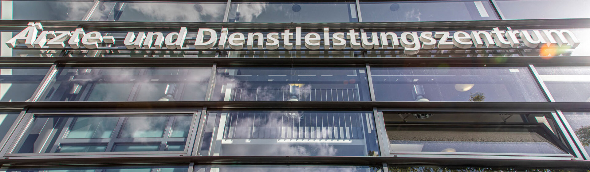 Weißer Schriftzug Ärzte- und Dienstleistungszentrum am Gebäude. Weißer Schriftzug Ärzte- und Dienstleistungszentrum am Gebäude.