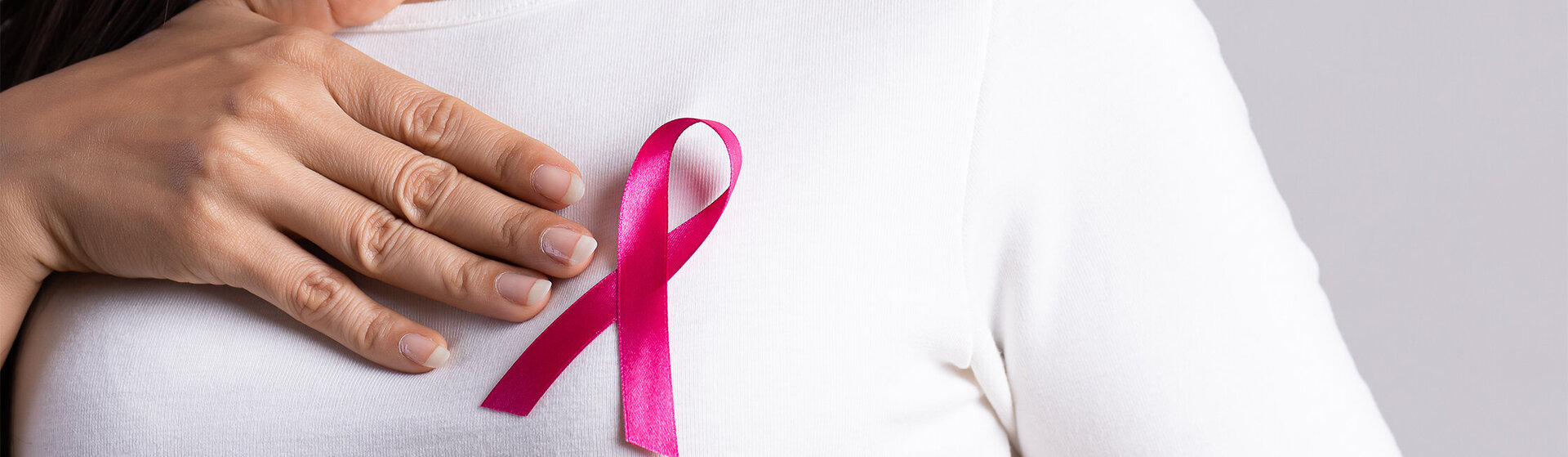 Oberkörper eine Frau mit einer Brustkrebsschleife.