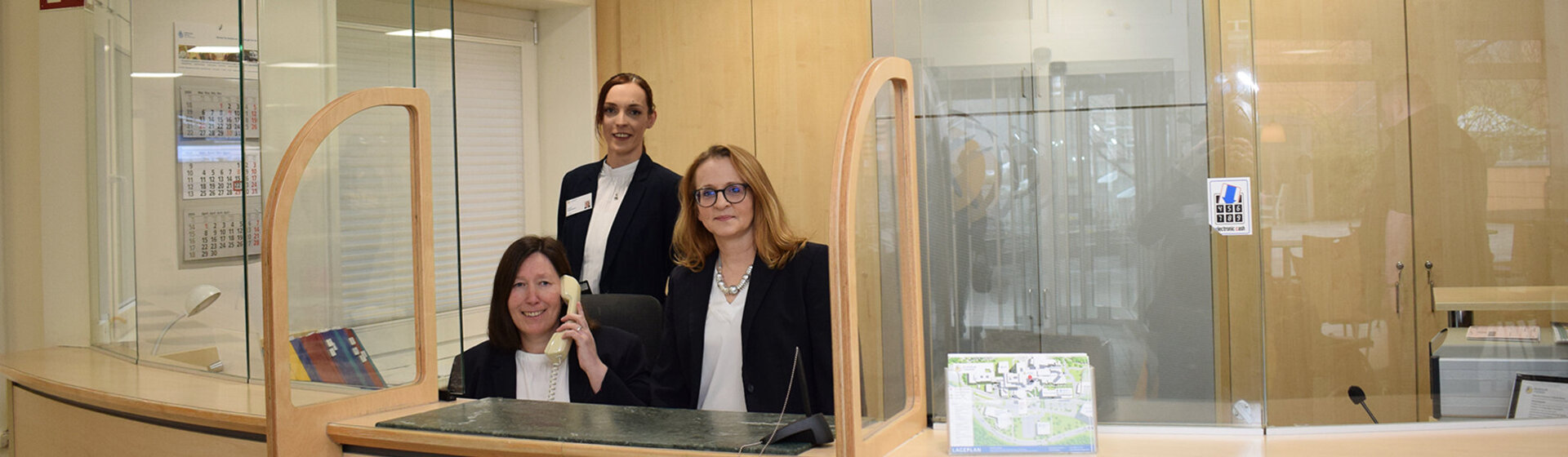 Drei Rezeptionistinnen am Tresen der Rezeption des Klinikums Itzehoe.