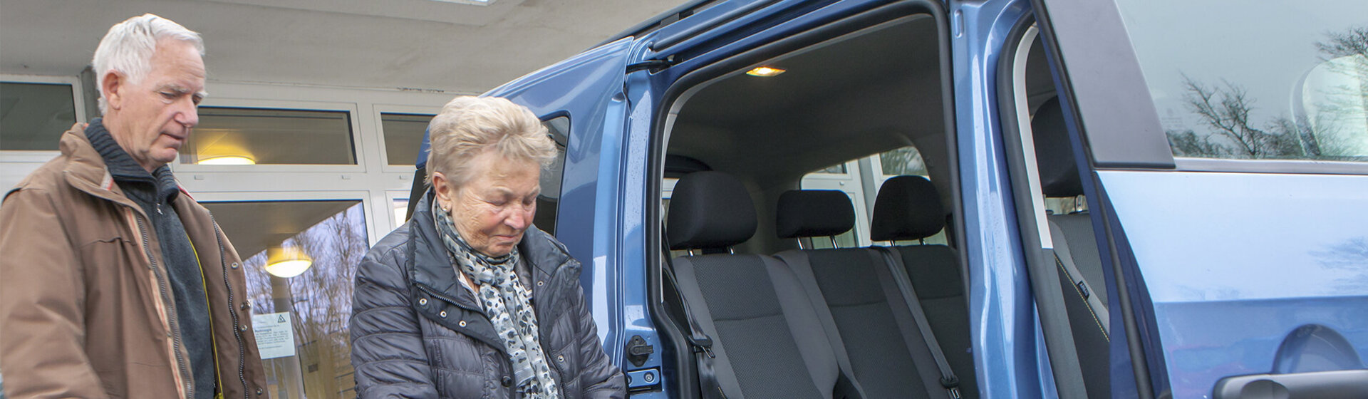 Der Fahrer holt eine ambulante Patientin vor der Geriatrischen Tagesklinik mit dem Kleinbus ab.