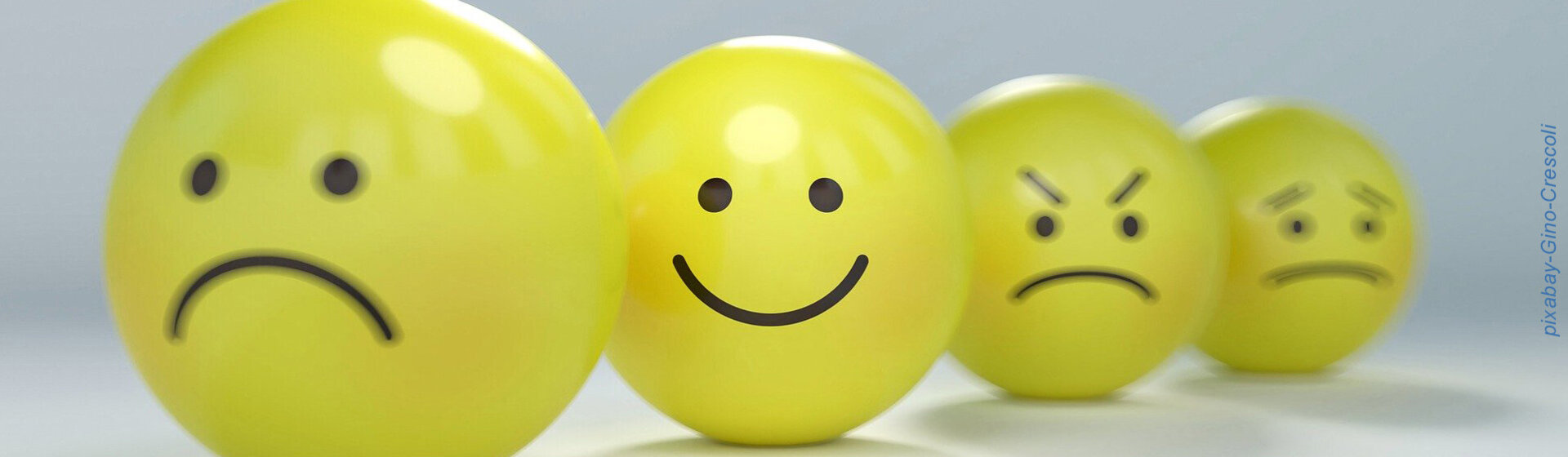 Gelbe Bälle mit Gesichtern in unterschiedlichen Emotionen.
