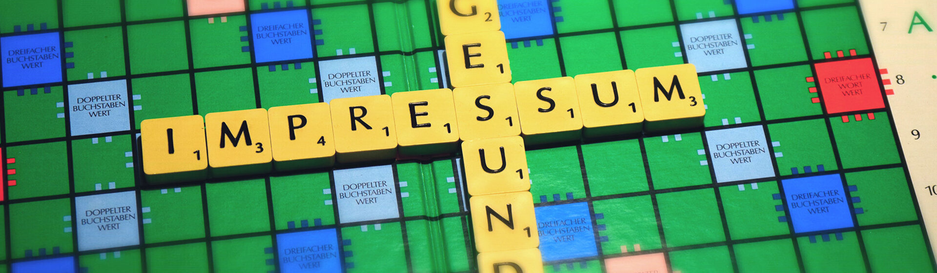 Scrabble auf dem das Wort Impressum steht.