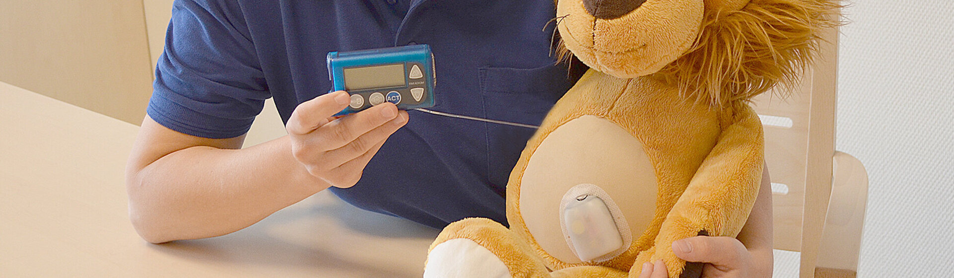 Oberärztin Nadine Scheffler hält ein Blutzuckermessgerät in der Hand, neben ihr am Tisch sitzt ein Kuscheltier (Löwe). Oberärztin Nadine Scheffler hält ein Blutzuckermessgerät in der Hand, neben ihr am Tisch sitzt ein Kuscheltier (Löwe).