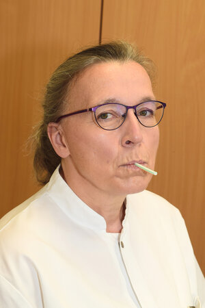 Atemtherapeutin Anke Strothmann demonstriert die Ausatmung über ein Röhrchen.