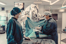 Zwei MitarbeiterInnen vom medizinischen Fachpersonal während einer OP. Zwei MitarbeiterInnen vom medizinischen Fachpersonal während einer OP.