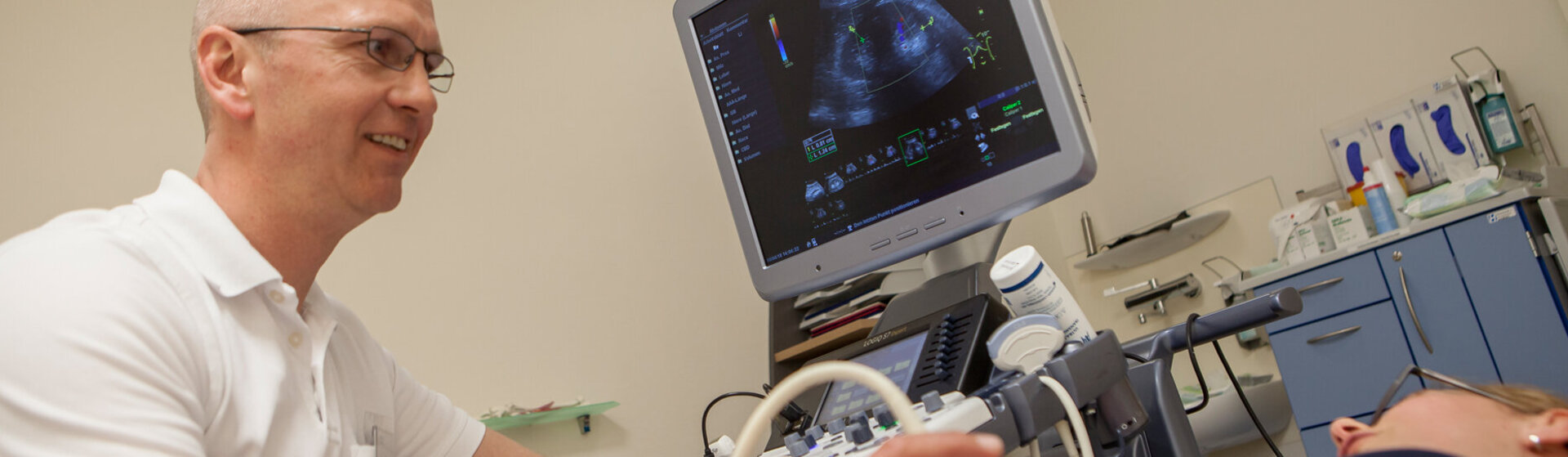 Leitender Arzt der Gefäßchirurgie Dr. med. Jörn Pfeiffenberger untersucht eine Patientin per Sonografie.