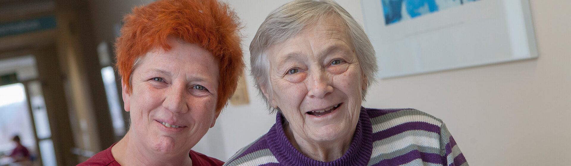 Eine Pflegefachkraft ist mit einer Patientin auf dem Flur der Geriatrischen Tagesklinik unterwegs. Eine Pflegefachkraft ist mit einer Patientin auf dem Flur der Geriatrischen Tagesklinik unterwegs.