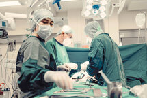 Drei MitarbeiterInnen vom medizinischen Fachpersonal während einer OP. Drei MitarbeiterInnen vom medizinischen Fachpersonal während einer OP.