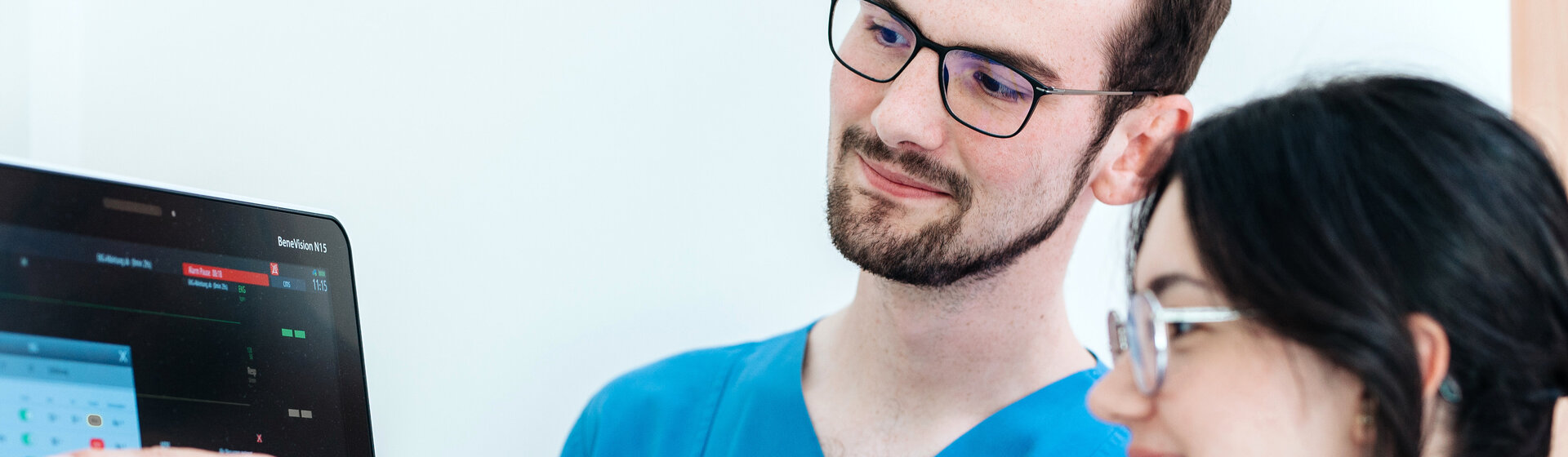 Zwei Pflegefachkräfte schauen auf einen Monitor. Zwei Pflegefachkräfte schauen auf einen Monitor.