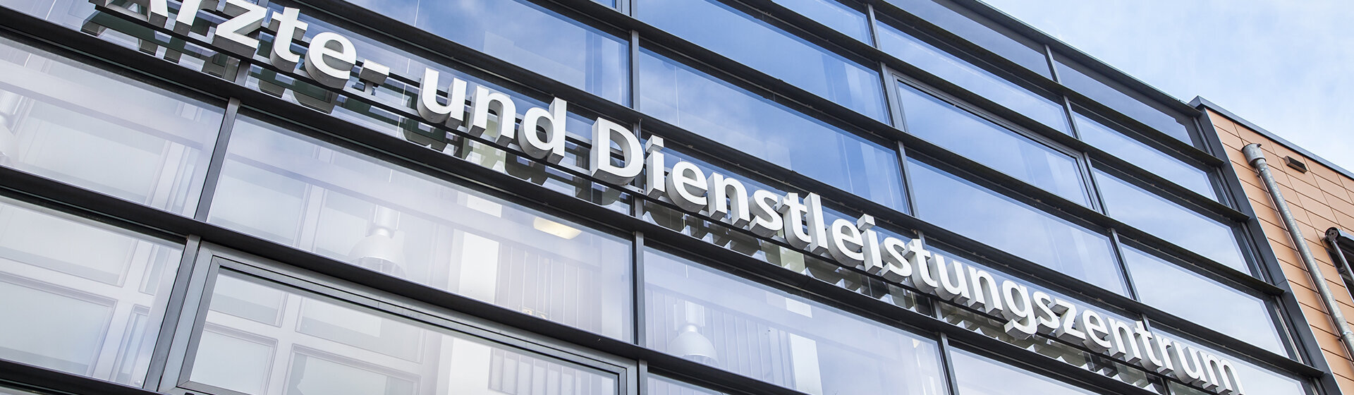 Glasfront oberhalb des Einganges mit Schriftzug Ärzte- und Dienstleistungszentrum Glasfront oberhalb des Einganges mit Schriftzug Ärzte- und Dienstleistungszentrum
