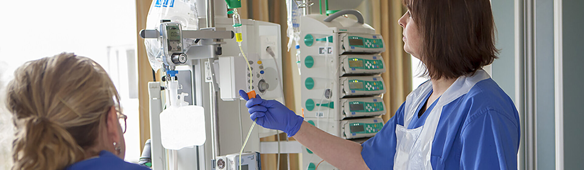 Pflegefachkräfte schließen Infusion an. Pflegefachkräfte schließen Infusion an.