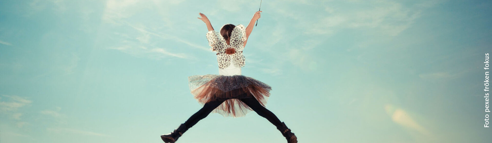Ein Mädchen in einem Elfenkostüm macht einen Luftsprung. Ein Mädchen in einem Elfenkostüm macht einen Luftsprung.