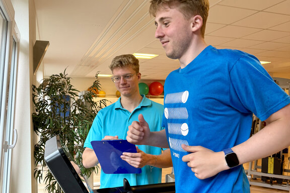 Trainierende Person auf Laufband wird von einem MediFit-Mitarbeitenden betreut.