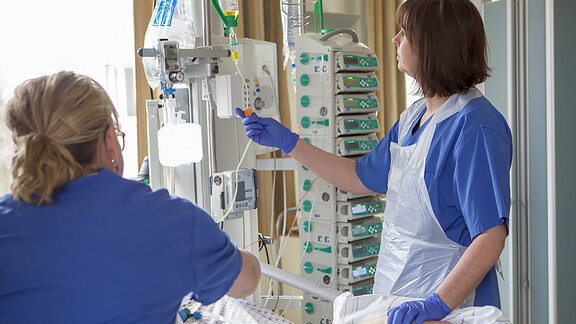 Pflegefachkräfte schließen Infusion an.