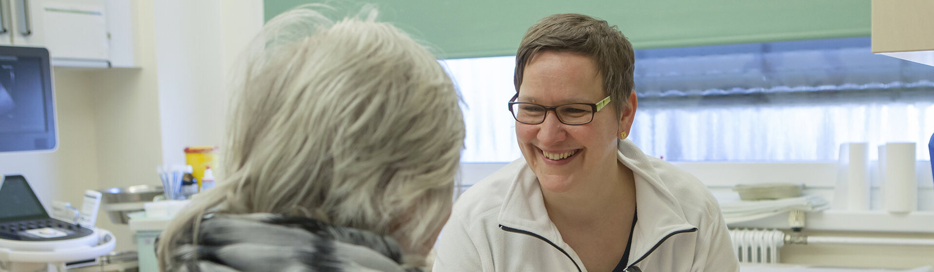 Ärztin lächelt Patientin an.