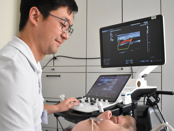 Chefarzt Prof. Dr. Chi-un Choe untersucht einen Patienten.